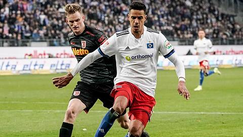 Regensburgs Scott Kennedy (l) und Hamburgs Robert Glatzel kämpfen um den Ball.