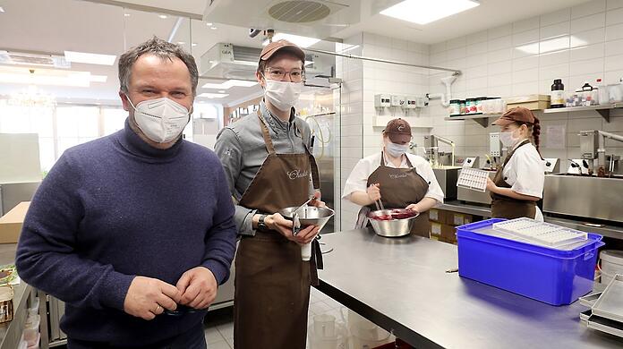 Olaf Minet (l.) bietet im Lockdown Fortbildungen für junge Köche und Koch-Azubis an, die in Kurzarbeit sind. "Viele Betriebe haben geschlossen und junge Menschen in der Ausbildung wenig Chancen, sich weiterzuentwickeln", sagt Minet. Diese Woche ist Koch Markus Hildebrecht zu Gast, um den Schoko- und Pralinenprofis der "Chocolat Manufaktur"über die Schulter zu schauen. Kommende Woche Montag wird ein Koch-Azubi aus dem Romantikhotel Fürstenhof für ein Praktikum bei Minet anfangen. "Wir könnten jede Wochen jemanden aufnehmen", sagt der Chocolatier.