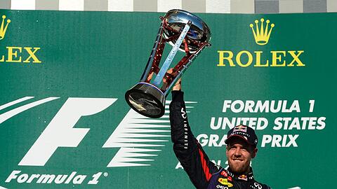 Der ehemalige deutsche Formel-1-Fahrer Sebastian Vettel mit seiner Trophäe für den Sieg beim Großen Preis der USA 2013.