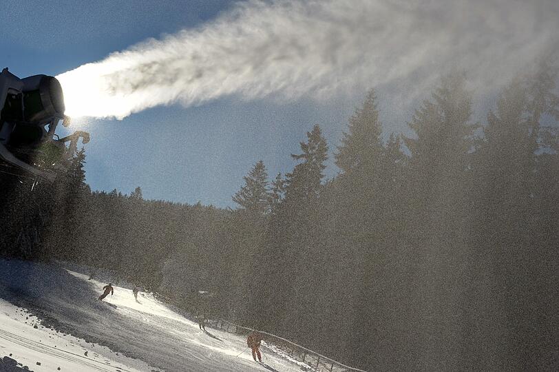 Immer mehr zu sehen: Der Niederschlag einer Schneekanone leuchtet am Ochsenkopf in Bischofsgrün in der Sonne.