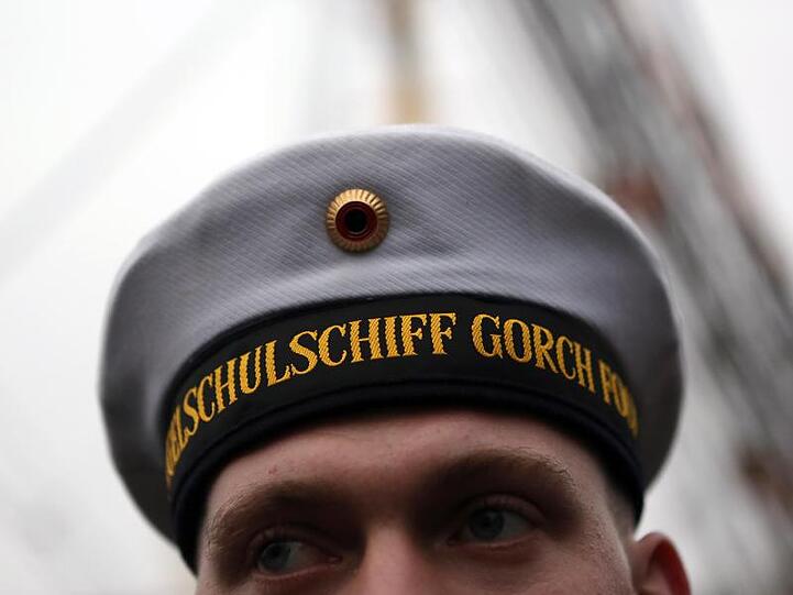 Ein Besatzungsmitglied des Marineschulschiffes steht vor dem Auslaufen aus dem Marinehafen an Bord.