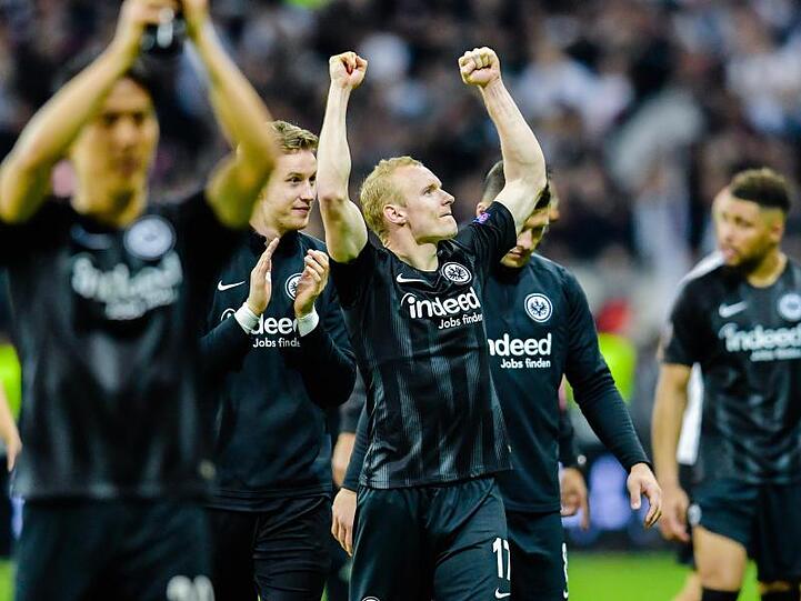 Die Eintracht-Spieler um Torschütze Rode (M) jubeln nach Spielende mit den Fans über das Weiterkommen.