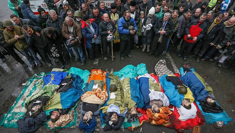 Stilles Gedenken für getötete Demonstranten: Auf dem Maidan haben sich die Menschen zu einer spontanen Trauerfeier zusammengefunden. Stilles Gedenken für getötete Demonstranten: Auf dem Maidan haben sich die Menschen zu einer spontanen Trauerfeier zusammengefunden.
