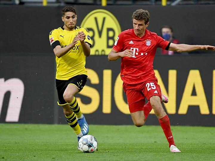 Dortmunds Achraf Hakimi und Münchens Thomas Müller (l-r.) in Aktion. Foto: Federico Gambarini/dpa-Pool/dpa