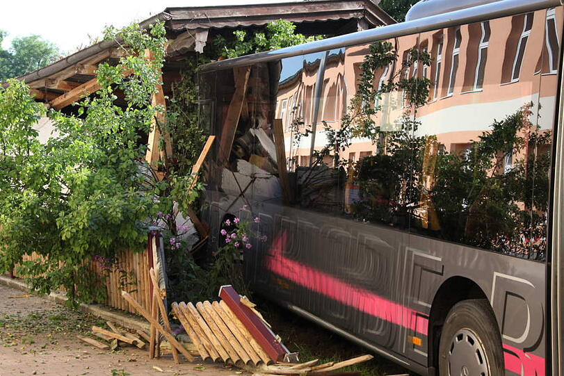 Ein Schulbus bricht durch einen Gartenzaun und verwüstet den Garten dahinter. Die irren Bilder.