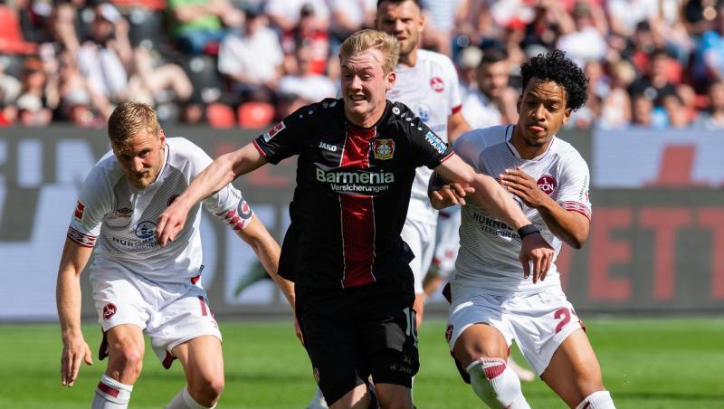 Bayer-Profi Julian Brandt (M.) enteilt den Nürnbergern Sebastian Kerk (l) und Matheus Pereira. Bayer-Profi Julian Brandt (M.) enteilt den Nürnbergern Sebastian Kerk (l) und Matheus Pereira.