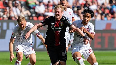 Bayer-Profi Julian Brandt (M.) enteilt den Nürnbergern Sebastian Kerk (l) und Matheus Pereira.
