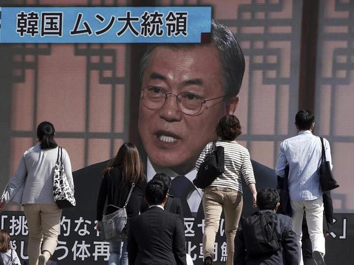Passanten gehen an einem Bildschirm vorbei, auf dem eine Nachrichtensendung mit dem südkoreanischen Präsidenten Moon Jae-in zu sehen ist. Der südkoreanische Präsident Moon forderte Nordkorea auf, von Handlungen Abstand zu nehmen, die die Diplomatie behindern könnten.