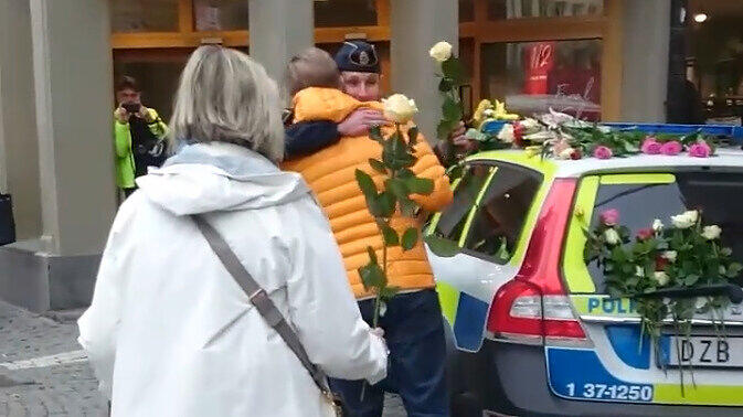 Um ihre Dankbarkeit auszudrücken, überreichen Menschen der schwedischen Polizei Blumen.