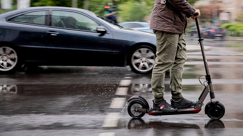 Ein E-Tretroller auf nasser Straße. Bald werden sie auf Deutschlands Straßen fahren dürfen.