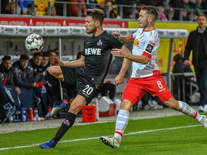 Salih Özcan vom 1. FC Köln (l) und Andreas Geipl von Jahn Regensburg kämpfen in der Continental Arena um den Ball. Foto: Armin Weigel
