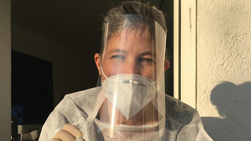 So nimmt Katharina Jäger auf dem Balkon vor ihrem Behandlungszimmer jeden Tag Corona-Abstriche vor.