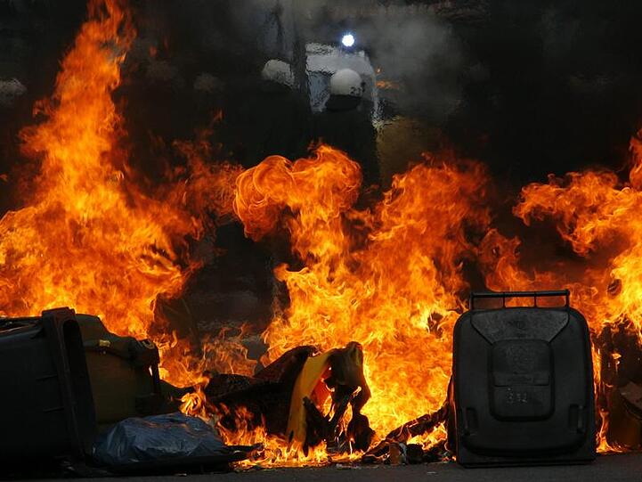 Polizisten räumen in Hamburg eine brennende Barrikade.