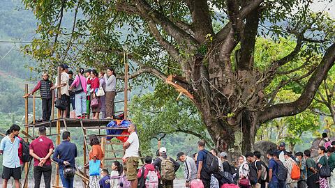 Menschen im Katastrophengebiet in Nepal warten darauf, in eine provisorische Seilbahn besteigen zu k&ouml;nnen.