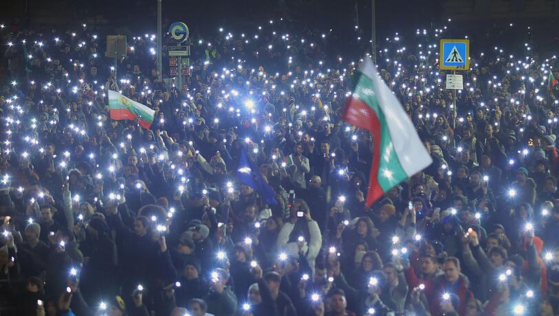 Menschen gingen mit Flaggen und Lichtern auf die Stra&szlig;e.