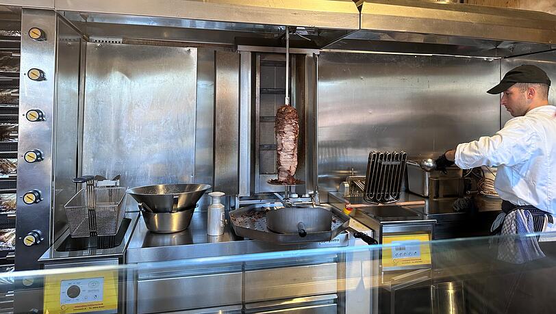 Brutzelnd dreht sich hinter der Theke ein Spieß, der stark an den in einem Döner-Laden erinnert. Brutzelnd dreht sich hinter der Theke ein Spieß, der stark an den in einem Döner-Laden erinnert.