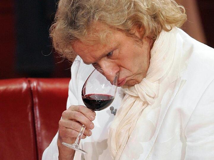 Thomas Gottschalk schaut in ein Rotweinglas. Foto: Jörg Carstensen/dpa/Archivbild