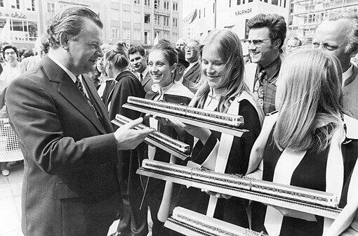 Schaut&rsquo;s Mädels, so sehen die neuen Züge aus: Der bayerische Wirtschaftsminister Anton Jaumann (CSU) hält bei der Eröffnung der Münchner S-Bahn ein Modell in der Hand.