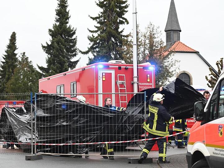 Feuerwehrleute errichten Sichtblenden an der Stelle, an der das Auto in den Rosenmontagsumzug gefahren war.