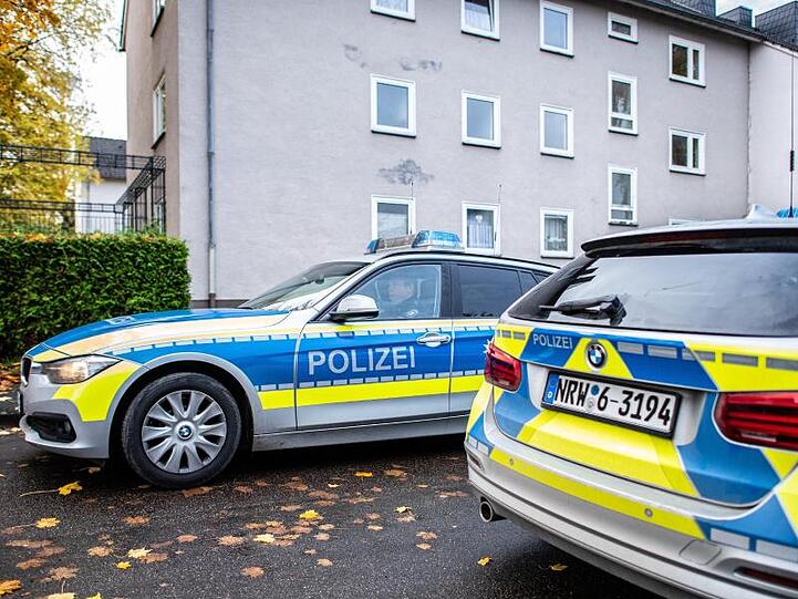 Polizeifahrzeuge vor dem Mehrfamilienhaus in Detmold, in dem eine 15-Jährige ihren dreijährigen Halbbruder erstochen haben soll.
