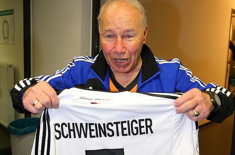 Karsten Wettberg hält das Trikot von Bastian Schweinsteiger in die Höhe. Es soll Olaf Bodden helfen.