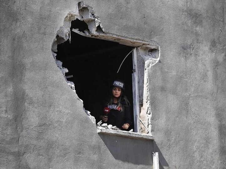 Eine Journalistin schaut aus einem Loch in der Wand eines Hauses in Akçakale, das von einem Mörser aus Syrien beschädigt wurde. Niemand wurde durch den Angriff verletzt.