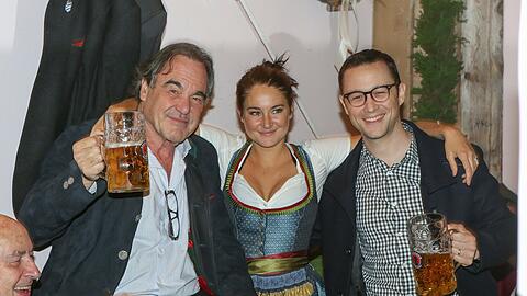 Bei aller kritischen Haltung: Oliver Stone kann auch feiern, wie hier auf dem Oktoberfest am Dienstag im Käferzelt mit seinem Hauptdarsteller Joseph Gorden-Levitt, der Edward Snowden spielt. Zwischen den beiden strahlt Shailene Woodley, die im Film Snowdens Freundin verkörpert.