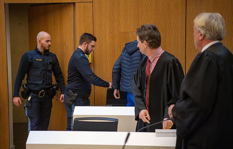 Einer der Angeklagten im Prozess um den Raubmord von Meiling (3.v.l) wird in den Gerichtssaal der JVA Stadelheim geführt.