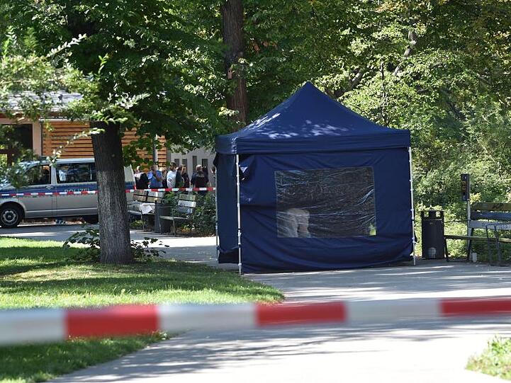 Beamte der Spurensicherung arbeiten am Tag der Tat am Tatort im Kleinen Tiergarten in einem Faltpavillon.