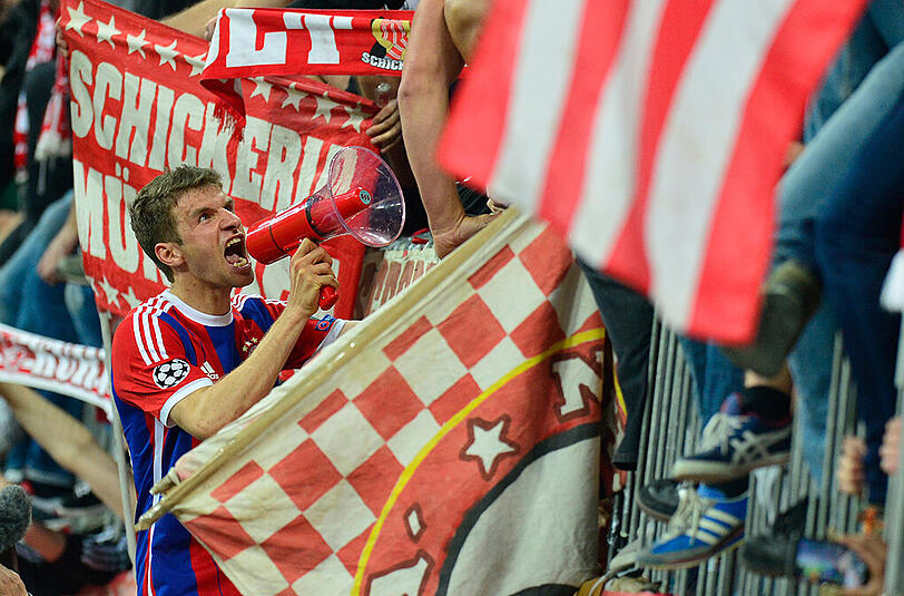 Thomas Müller vom FC Bayern München schreit nach dem Sieg gegen den FC Porto durch ein Megafon zu den Fans.