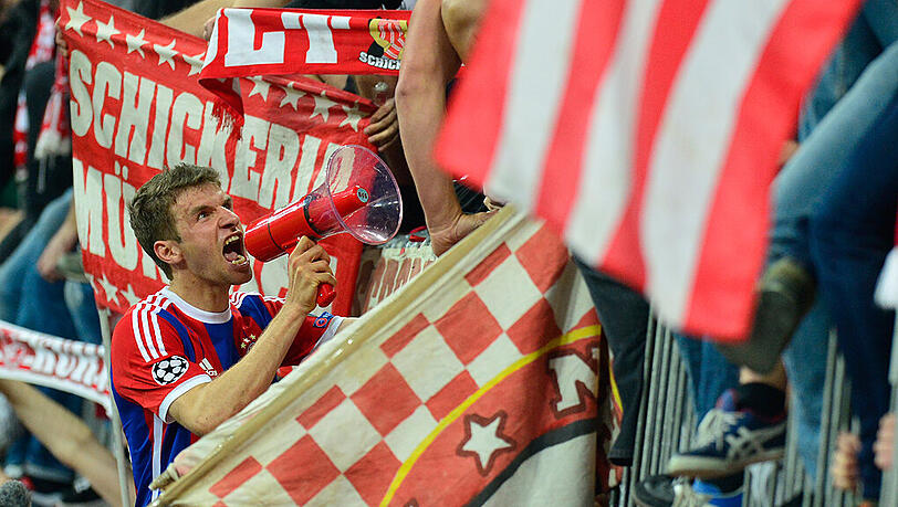 Thomas Müller vom FC Bayern München schreit nach dem Sieg gegen den FC Porto durch ein Megafon zu den Fans. Thomas Müller vom FC Bayern München schreit nach dem Sieg gegen den FC Porto durch ein Megafon zu den Fans.