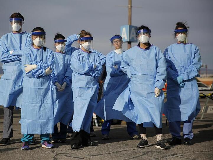 Medizinstudenten und Arzthelferinnen in Schutzkleidung stehen zusammen, bevor sie in einem Camp in Las Vegas Obdachlose auf eine mögliche Infizierung testen.
