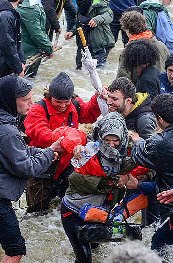 Hunderte Flüchtlinge aus dem Lager in Idomeni durchqueren einen reißenden Fluss auf griechischer Seite, um illegal nach Mazedonien zu gelangen.