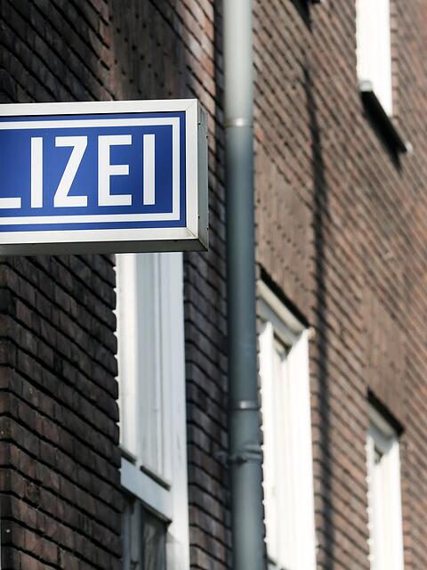 Ein Schild mit der Aufschrift "Polizei" hängt an einem Polizeipräsidium.