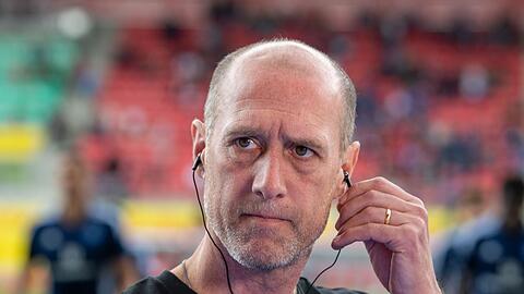 Regensburgs Trainer Joe Enochs steht im Stadion.