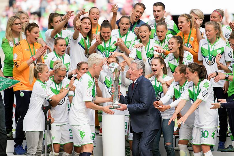 Bundespräsident Joachim Gauck überreicht Wolfsburgs Spielführerin Nilla Fischer den Pokal.