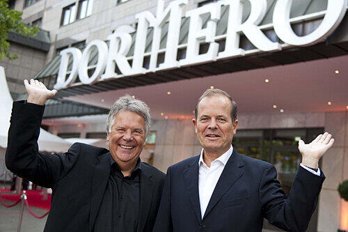 ans Rudolf Wöhrl (l.) und Henning von der Forst (Nürnberger Versicherung) vor dem 4-Sterne-Hotel &bdquo;Dormero&ldquo; in Hannover.