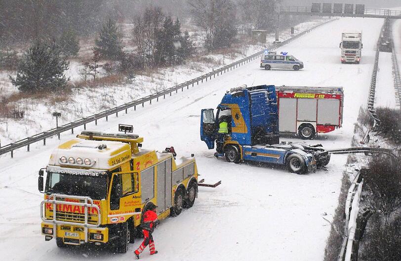 Abschleppwagen bergen auf der A2 einen verunfallten Lastwagen, der bei winterlichen Straßenverhältnissen und Schneetreiben in die Leitplanke gerutscht ist.