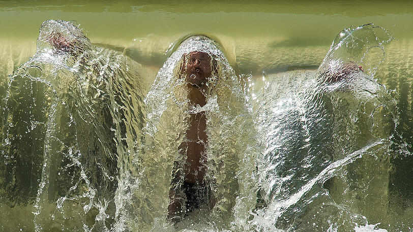 Kühler Kopf trotz Hitze &ndash; Michael genießt die kalte Dusche am kleinen Wasserfall im Eisbach im Englischen Garten.
