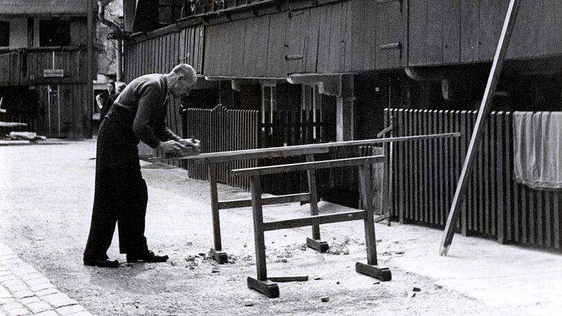 Handwerkliche Tätigkeiten auf der Straße sind damals in der Au ein alltägliches Bild.