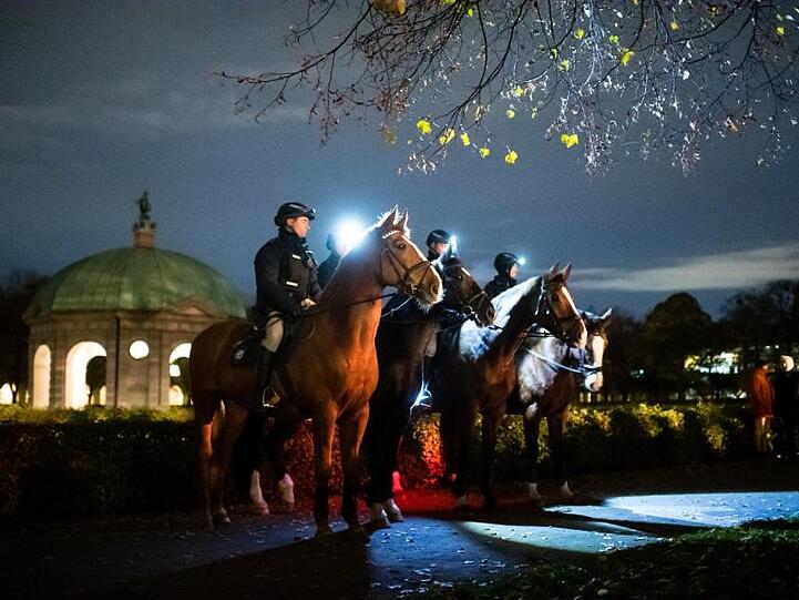 Polizisten auf Pferden bewachen das Bundeswehr-Gelöbnis im Münchner Hofgarten. Foto: Matthias Balk/dpa