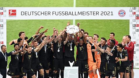 Die Mannschaft des FC Bayern München jubelt mit der Meisterschale.