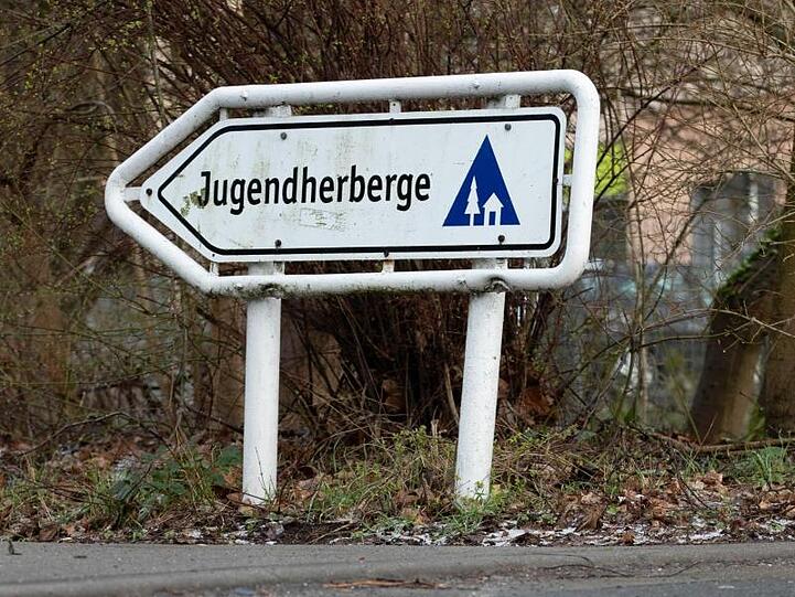 Blick auf einen Wegweiser vor einer Jugendherberge. Foto: Friso Gentsch/dpa/Archivbild
