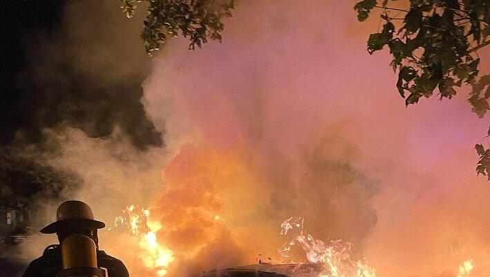 Ein Feuerwehrmann löscht in der Nacht auf Freitag am Mariahilfplatz den Mercedes.  Branddirektion