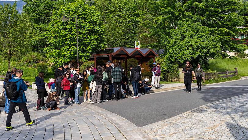 Eine Touristengruppe steht an einer Bushaltestelle in Schönau. (Archivbild)