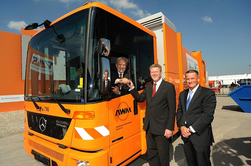 Münchens Abfallchef Helmut Schmid sitzt am Steuer eines neuen Hybrid-Fahrzeugs. Mit dabei: Bayerns Umweltminister Marcel Huber und Burkhard Oppmann von der Herstellerfirma Faun.