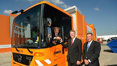 Münchens Abfallchef Helmut Schmid sitzt am Steuer eines neuen Hybrid-Fahrzeugs. Mit dabei: Bayerns Umweltminister Marcel Huber und Burkhard Oppmann von der Herstellerfirma Faun.