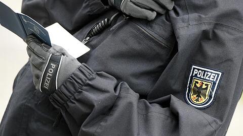 Ein Polizist überprüft Personalien. Beim Racial Profiling werden Menschen auf Grundlage von Stereotypen und äußerlichen Merkmalen als verdächtig eingestuft und überprüft.