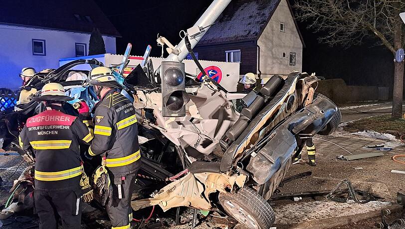 Rettungskräfte an der Unfallstelle vor dem Wrack des BMW. Rettungskräfte an der Unfallstelle vor dem Wrack des BMW.