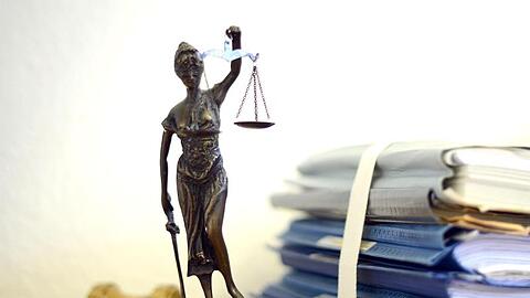 Justitia mit Holzhammer und Aktenstapel. Foto: Volker Hartmann/dpa/Symbolbild